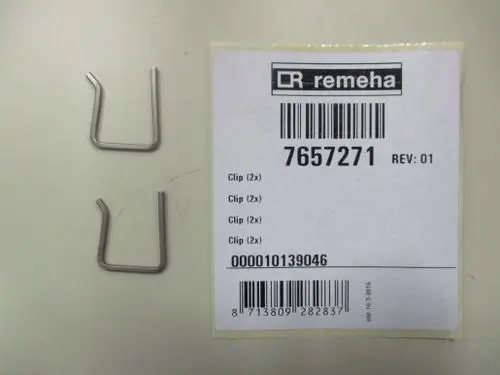 Zwei metallene Clips, abgelegt auf einer Fläche. Daneben ein weißes Etikett mit der Marke Remeha und Barcode-Informationen.